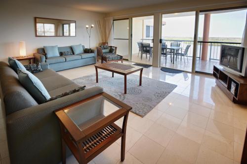 a living room filled with furniture and a large window at On The River Apartments in Maroochydore