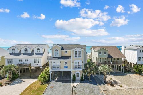 an image of a house with the ocean in the background at Inn Between in Holden Beach