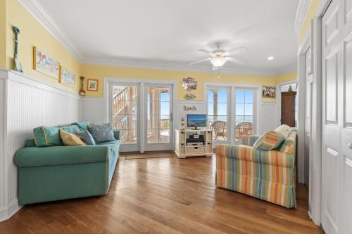 a living room with two chairs and a television at Inn Between in Holden Beach