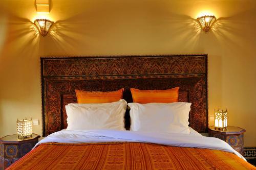 1 dormitorio con 1 cama grande y 2 lámparas en Riad Ibn Battouta & Spa, en Fez