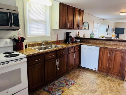 a kitchen with wooden cabinets and a white stove top oven at Hidden Treasure in Holden Beach