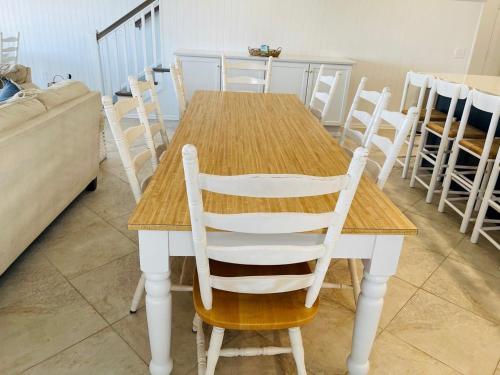 a wooden table with white chairs around it at Avalon East-Duplex in Holden Beach