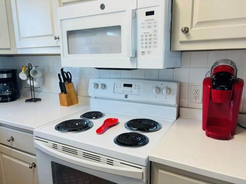 a kitchen with a white stove and a red blender at Sea Biscuit in Holden Beach