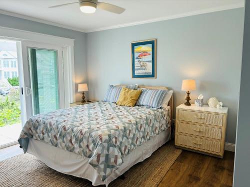 a bedroom with a bed and two lamps and a window at Nauti Time home in Holden Beach