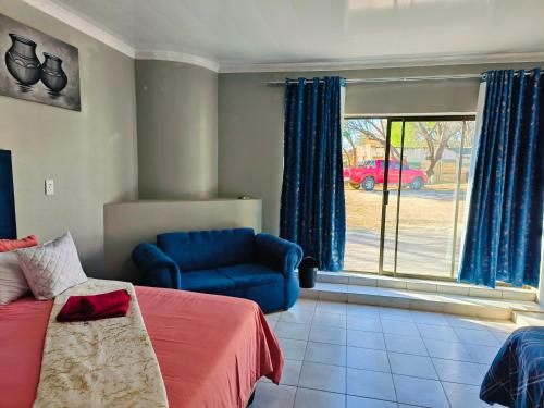a bedroom with a bed and a couch and a window at Ave Maria Camping site in Welkom