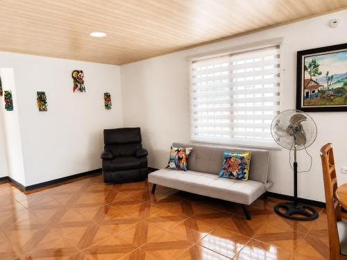 a living room with a couch and a fan at Alojamiento Vistas Chirripo espacioso con Parqueo in San Isidro de El General