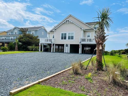 a house with a palm tree in the driveway at Avalon West-Duplex in Holden Beach
