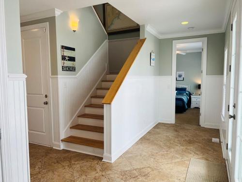a staircase in a home with white walls and wooden stairs at 287 OBW home in Holden Beach