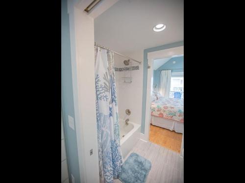 a bathroom with a tub and a shower curtain at The Sandbox home in Holden Beach