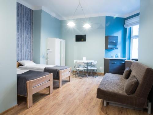 Un dormitorio con una cama, un sofá y una mesa. en Just4You Apartments, en Cracovia