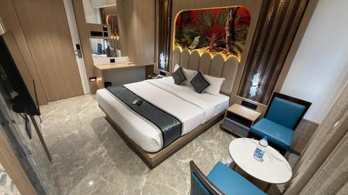 a bedroom with a large bed and a blue chair at Hotel Shree Krishna Paradise Dombivali in Dombivli