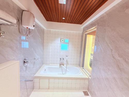 a large bathroom with a tub and a window at Hotel Shree Krishna Paradise Dombivali in Dombivli
