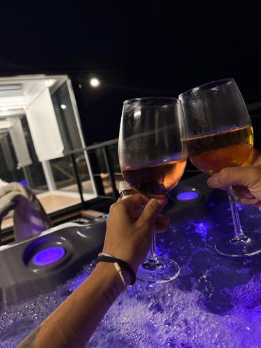 two people holding glasses of wine on a hot tub at Lua Mazamitla in San Luis Soyatlán