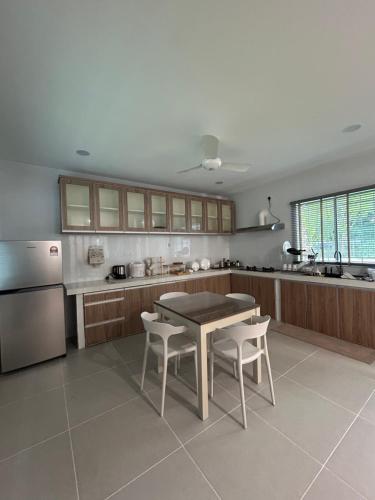 a kitchen with a table and chairs and a refrigerator at Haus176 in Bentong