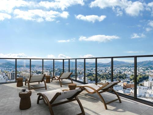 a balcony with chairs and a view of a city at FAV LUX Asahikawa in Asahikawa