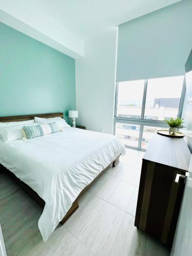 a bedroom with a large bed and a large window at Sleek 2BD 2BA Condo In Miami Design District in Miami