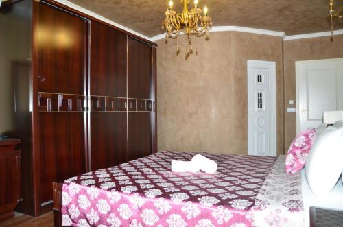 a bedroom with a bed and a chandelier at Hotel Begolli in Pristina