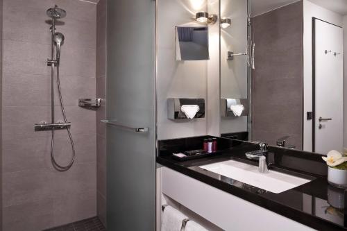a bathroom with a sink and a shower at INNSiDE by Meliá Wolfsburg in Wolfsburg