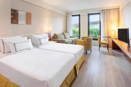 a hotel room with a large bed and a living room at Meliá Luxembourg in Luxembourg