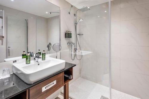 a bathroom with a sink and a shower at Meliá Luxembourg in Luxembourg