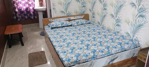 a bedroom with a bed with blue and white sheets at Destiny Lodge & Homestay in Nāzirā