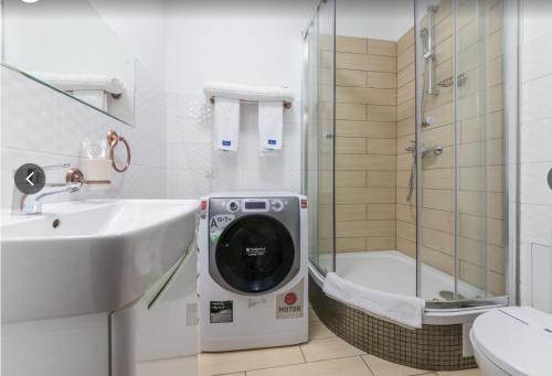a bathroom with a washing machine next to a sink at G40 Boutique Hotel in Odesa