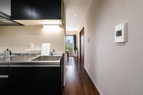a kitchen with a sink and a counter top at Hotel Piacere NAMBA in Osaka