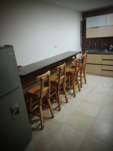 a kitchen with a row of wooden tables and chairs at Multiverse Hostel in Medellín