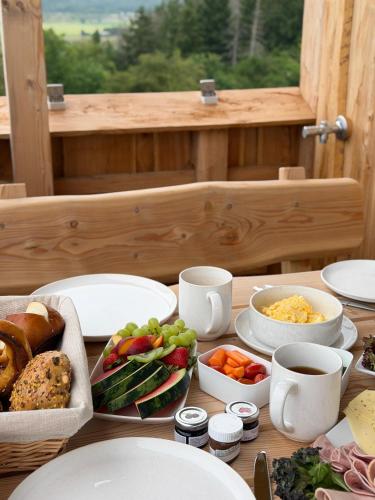 a table with plates and bowls of food on it at Sky Chalets Bühlertal in Bühlertann