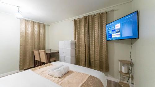a bedroom with a bed and a tv on a wall at Luvienna Stays in Winnipeg