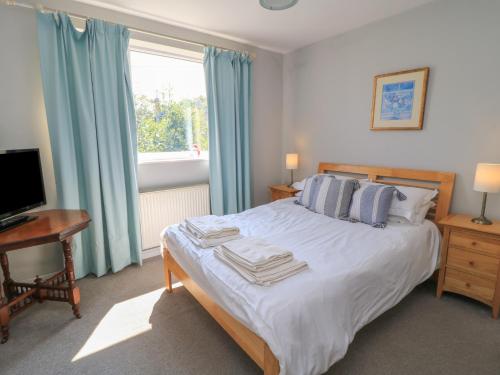 ein Schlafzimmer mit Bett, Schreibtisch und Fenster in der Unterkunft Lamora in Cheddar