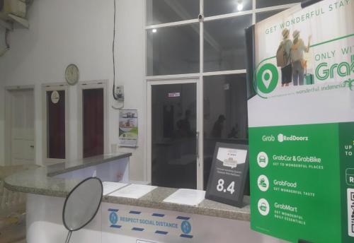 a store with a sign in front of a counter at Hotel O Wisma Fortuner in Makassar