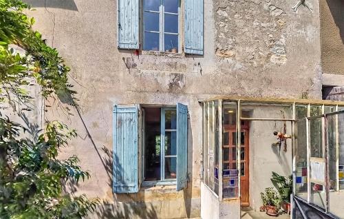an old building with blue windows and a door at Charmante Maison 