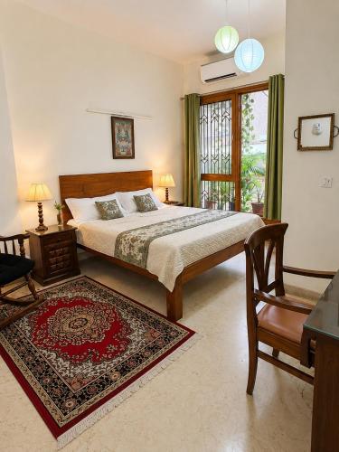 a bedroom with a king sized bed and a chair at Dr Balis Bliss Homestay in New Delhi