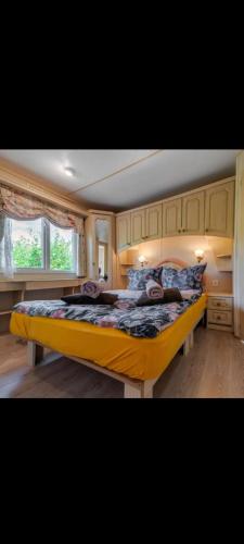 a bedroom with a large yellow bed in a room at Agroturystyka u Kozdryka in Leśna