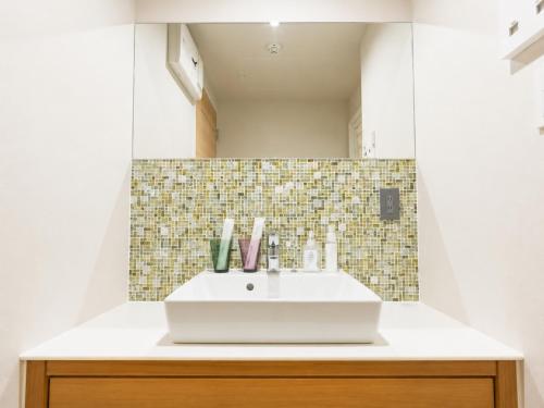a bathroom with a sink and a mirror at Nagi Kurashiki Hotel&Lounge in Kurashiki