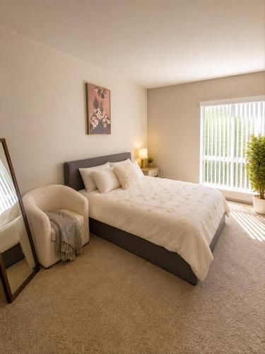 a bedroom with a large bed and a chair at 1-Bedroom Apartment near ALX Airport and the Ocean in Los Angeles