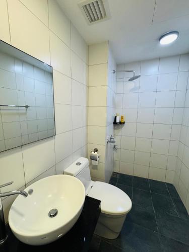 a bathroom with a white toilet and a sink at Chambers Elite Suites KLCC in Kuala Lumpur