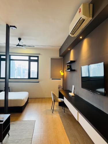 a bedroom with a bed and a desk and a tv at Chambers Elite Suites KLCC in Kuala Lumpur