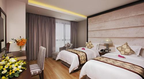 a hotel room with two beds and a window at Athena Hotel in Ho Chi Minh City