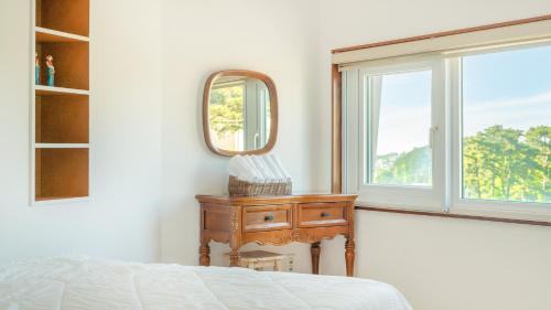 a bedroom with a bed and a mirror and a table at goseong theprism pension in Goseong