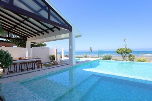 a swimming pool with a view of the ocean at Alesea Baroro, La Union, Private Modern Villa with Pool, Jacuzzi, Beachfront View in Balio