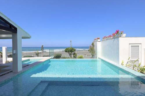 a swimming pool with a view of the ocean at Alesea Baroro, La Union, Private Modern Villa with Pool, Jacuzzi, Beachfront View in Balio