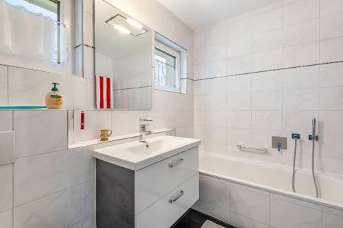 a white bathroom with a sink and a bath tub at Bernhards in Buch
