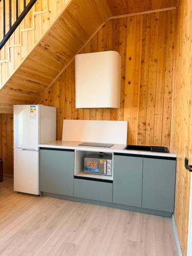 a kitchen with white appliances in a room with wooden walls at Barnhouse Allan in Koshkolʼ