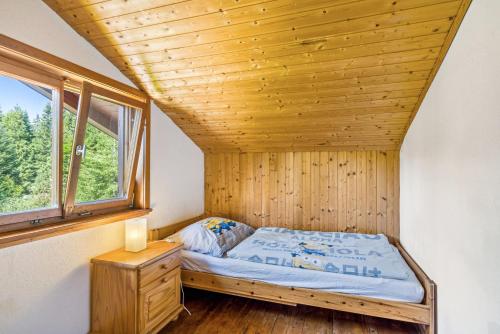 a bed in a room with a wooden ceiling at Haus Winterstaude in Egg