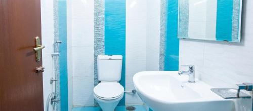 a bathroom with a toilet and a sink at Starlighthotels OMR Thoraipakkam Chennai in Chennai
