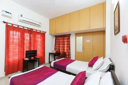 a hotel room with two beds and a television at Starlighthotels OMR Thoraipakkam Chennai in Chennai