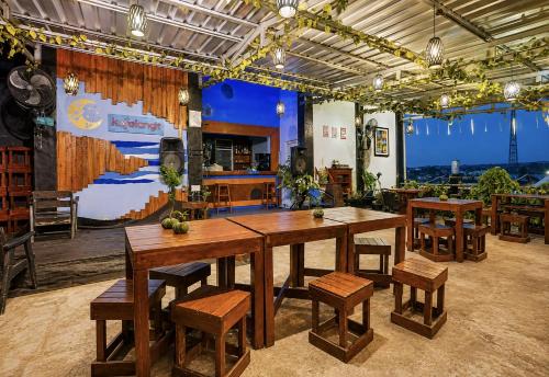 a dining room with a large wooden table and chairs at Townhouse Oak Hotel Lestari in Berpodak