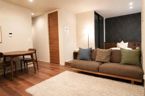 a living room with a couch and a table at SOULEIADO Shinosaka in Osaka